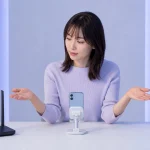 女性配信者がルーターと二台の端末を前に通信トラブルの原因を考えている