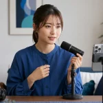 女性配信者が顔を隠さない位置にマイクを置きスマートフォンへ向かって話している