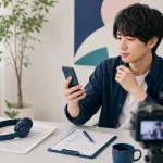 配信前にスマートフォンの状態と確認表を見る成人男性配信者